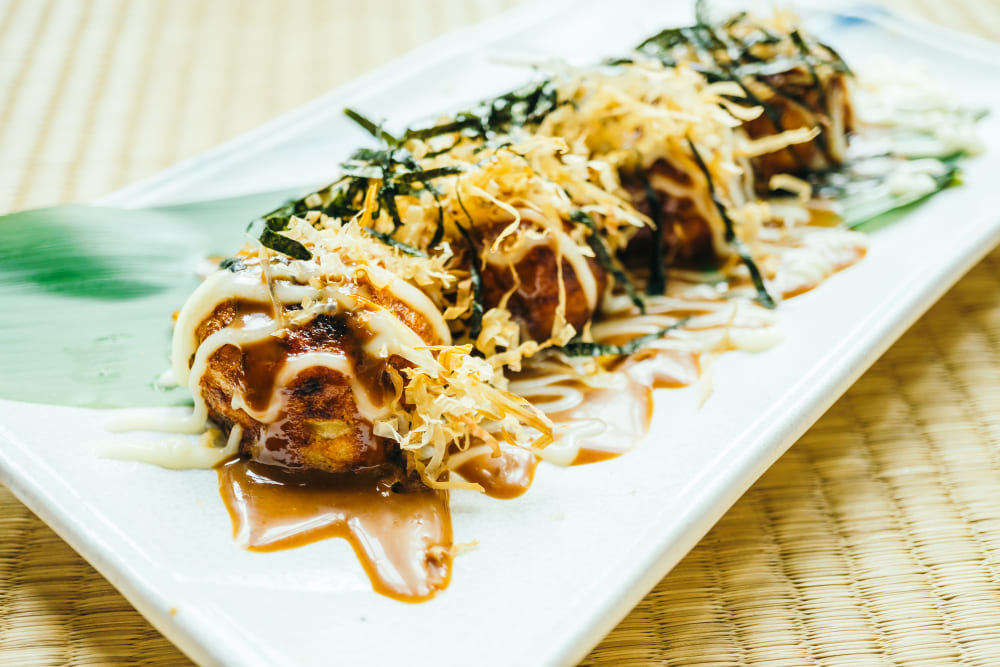 Takoyaki with tangy sauce, mayonnaise, and dancing bonito flakes.
